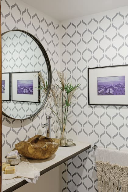 Paredes decoradas con esténcil (Las Lupes). Espejo de hierro con led diseñado por Javier Zaldívar. Bacha de raíz de teca importada sobre mesada de cemento alisado blanco.