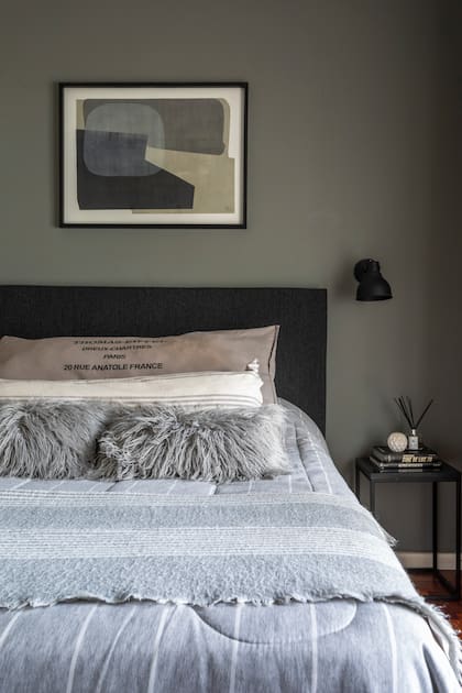 Paredes en tono ‘Thunderous’ (Sherwin Williams), acolchado (Arredo), pie de cama (Zara Home), almohadones (Teodolina Deco), mesas de noche (Ziba).