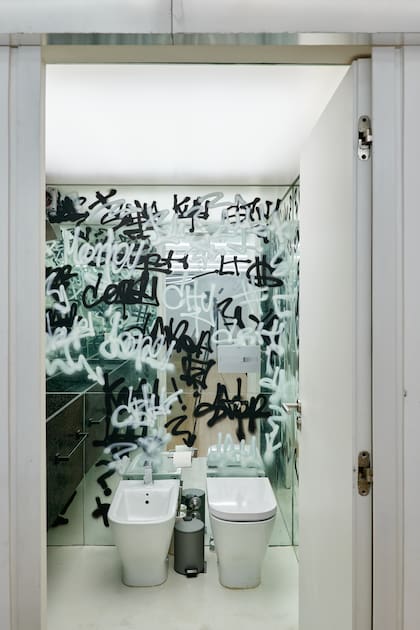 Paredes revestidas de espejos granitados, techo de tela de PVC tensada (Tela Wagg). Vanitory de granito negro 'Brasil Leather'. (Wollstudio).