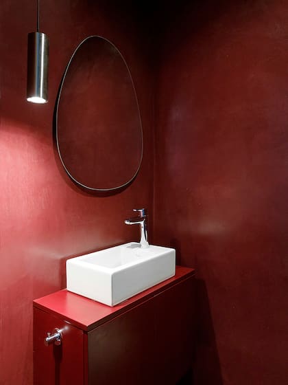 Paredes revestidas en micrcomento pintadas con el tono 'X016' de Quimtex, el mismo que se eligió para laquear el mueble que sostiene la bacha.