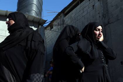 Parientes de un palestino, que murió durante la protesta en la frontera entre Israel y Gaza, llora durante su funeral en Khan Younis en el sur de la Franja de Gaza el 14 de mayo de 2018.