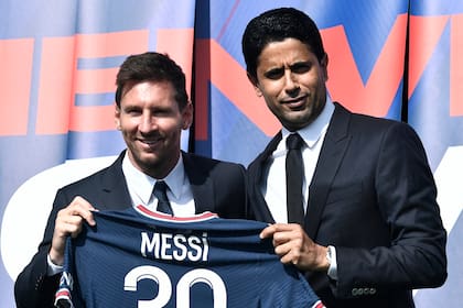 Paris Saint-Germain's Qatari President Nasser Al-Khelaifi (R) poses along side Argentinian football player Lionel Messi as he holds-up his number 30 shirt during a press conference at the French football club Paris Saint-Germain's (PSG) Parc des Princes stadium in Paris on August 11, 2021. - The 34-year-old superstar signed a two-year deal with PSG on August 10, 2021, with the option of an additional year, he will wear the number 30 in Paris, the number he had when he began his professional career at Spain's Barca football club. (Photo by STEPHANE DE SAKUTIN / AFP)