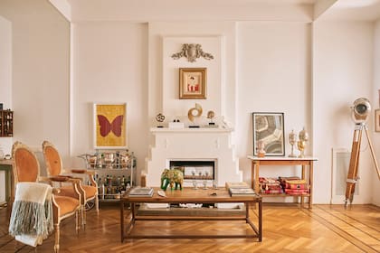 Parquet, molduras, techos altos y una chimenea singular: una muy buena base para desplegar la creatividad. Silloncitos franceses frente a una mesa ratona de aire industrial.