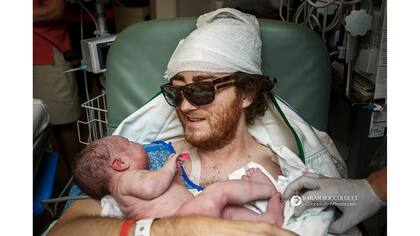 Un papá con cáncer cerebral sosteniendo a su bebé