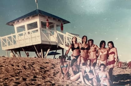 Parte del staff de modelos de Dotto frente a la casilla de bañero que construyó en Dotto Beach