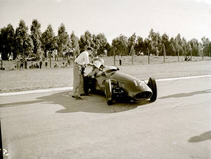 Particular forma de aplacar el calor en los GP de los 50 en Buenos Aires: Horace Gould se hidrata con la ayuda de un auxiliar