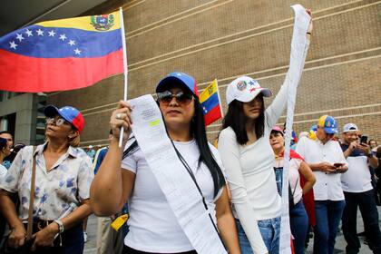 Partidarios de la oposición sostienen actas de recuento de votos durante una protesta contra los resultados de las elecciones presidenciales que declararon ganador al presidente Nicolás Maduro en Caracas, Venezuela, el sábado 17 de agosto de 2024. (Foto AP/Cristian Hernández)