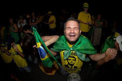 Partidarios del presidente brasileño Jair Bolsonaro, quien se postula para otro mandato, rezan mientras escuchan los resultados parciales luego del cierre de las urnas para las elecciones generales en Brasilia, Brasil, el domingo 2 de octubre de 2022. (Foto AP/Ton Molina)