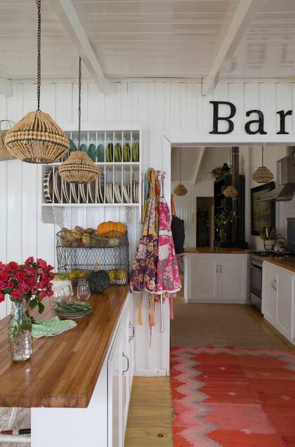 Partiendo de una mesada de madera, se fue configurando esta cocina con alma vintage. El mueble bajomesada hecho a medida se complementó con vajilleros antiguos de madera y contenedores de alambre (7-27 Home Collection).