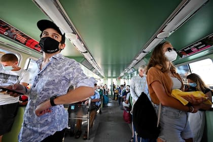 Pasajeros con barbijo en un ferry que llega a Venecia