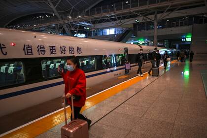 Pasajeros con mascarillas faciales como medida preventiva contra el coronavirus llegan a la estación de tren de Wuhan el 19 de noviembre de 2020