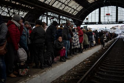 Pasajeros esperan en el andén de la estación de tren de Lviv, el domingo 27 de febrero de 2022, en Lviv, al oeste de Ucrania
