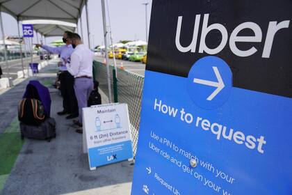 Pasajeros esperan la llegada de los vehículos del servicio Uber en una parada en el aeropuerto de Los Angeles, Estados Unidos