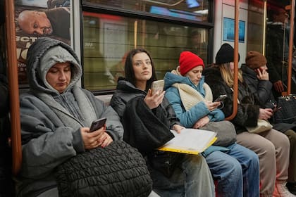 Pasajeros miran sus smartphones en el metro, en Moscú (Archivo)