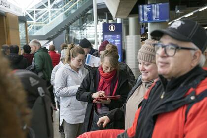 Pasajeros que iban a viajar con la aerolínea islandesa Wow esperan en fila en el aeropuerto internacional de Islandia en Keflavik