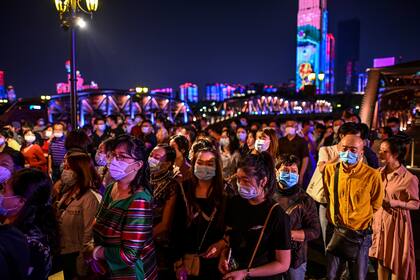 Pasajeros que usan mascarillas como medida preventiva contra el coronavirus esperan para abordar un barco en Wuhan, en la provincia central de Hubei, China, el 27 de septiembre de 2020