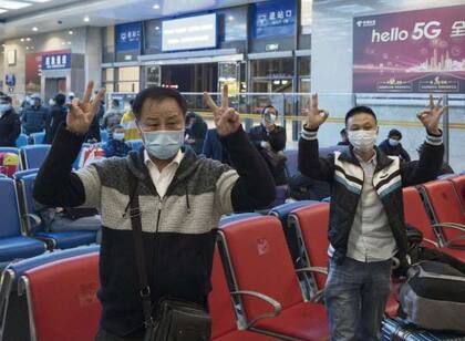 Pasajeros saludan el levantamiento de la cuarentena en la estación central de Wuhan,145x102mm