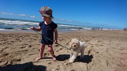 Paseando en la playa a su perrito Titi.