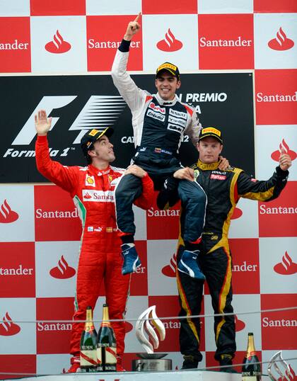 Pastor Maldonado es levantado por Fernando Alonso y Kimi Raikkonen; el piloto venezolano logró en el Gran Premio de España 2012 el último triunfo de Williams en la Fórmula 1