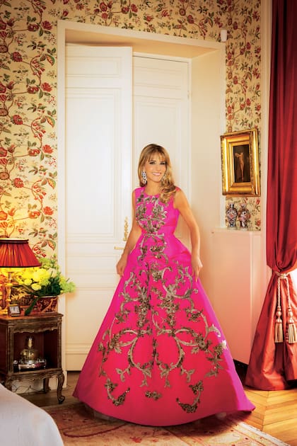 Patricia en su dormitorio, decorado en tonos claros y con cortinas de seda color bordó