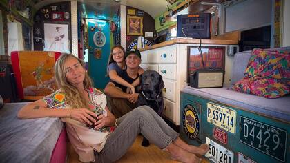 Patricia, Inti, Germán y la mascota Aurora, en el interior del autobús escolar que se convirtió en su hogar desde el año 2009