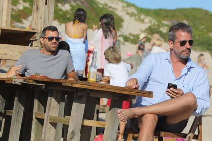 Patricio Giménez, celular en mano en la playa