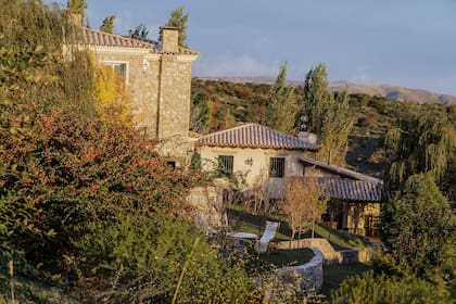 Patricio y su familia querían una casa de piedra con techo de tejas. El jardín natural de sauces, fresnos y álamos se fue subiendo para “abrazarla”.