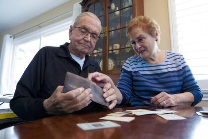Paul Grisham y su esposa Carole Salazar revisan su billetera y los artículos que había dentro cuando perdió la billetera en 1968 en su casa en la sección de San Carlos de San Diego, California.