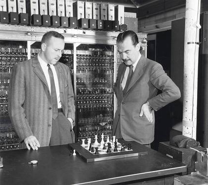 Paul Stein y Nicholas Metropolis frente al tablero de ajedrez modificado (sin alfiles) que se usó para competir con MANIAC