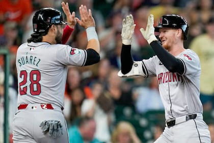 Pavin Smith, derecha, de los Diamondbacks de Arizona, celebra su cuadrangular de tres cerreras en contra de los Astros de Houston con Eugenio Suárez durante la segunda entrada del juego de béisbol del domingo 8 de septiembre de 2024, en Houston. (AP Foto/Eric Christian Smith)
