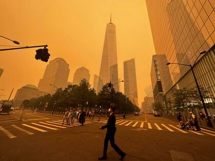 Peatones pasan junto al One World Trade Center (centro), en medio de la humareda causada por los incendios forestales en Canadá, el 7 de junio de 2023, en la Ciudad de Nueva York (AP Foto/Julie Jacobson)