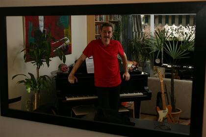 Pedro de entre casa, rodeado de instrumentos, libros y objetos musicales