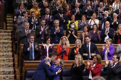 Pedro Sánchez, abajo a la izquierda, abraza a la vocepresidenta en funciones y ministra de Economía de España, Nadia Calviño, después de que fuera elegido por una mayoría absoluta