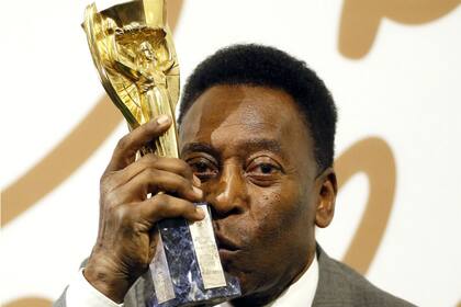Pelé y el trofeo Jules Rimet, que la FIFA le otorgó como campeón de tres mundiales