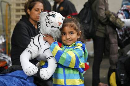 Una niña disfruta del tigre de peluche que recibió en la estación
