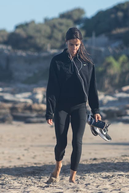 A pensativa Maria caminha pela areia, preocupada com olhares indiscretos.