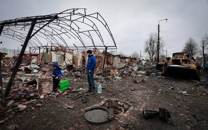 La gente mira el edificio destruido en la ciudad de Bucha, cerca de la capital, Kiev, Ucrania, el martes 1 de marzo de 2022.