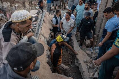 People search the rubble of homes in the mountain village of Imi N'Tala, south of Marrakech, on September 10, 2023. The death toll from Morocco's devastating earthquake has risen to 2,497, the interior ministry said on September 11, as search and rescue efforts continue. (Photo by Matias CHIOFALO / AFP)�