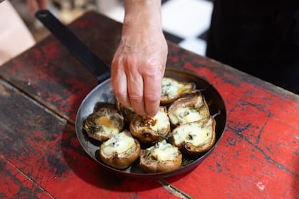 Peras rostizadas al horno de leña rellenas de queso azul, nueces y miel con curry.