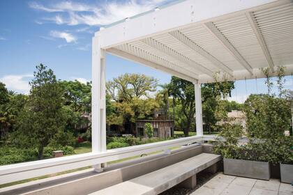 Pérgola que genera sombra inmediata y permite el uso de la terraza como expansión del salón de usos múltiples. 