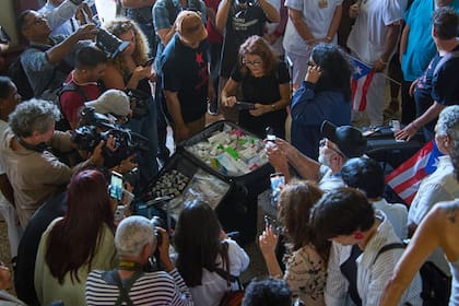 Periodistas toman fotografías de una de las maletas que contienen medicamentos donados al Hospital Salvador Allende como parte del convoy "Nuestra América"