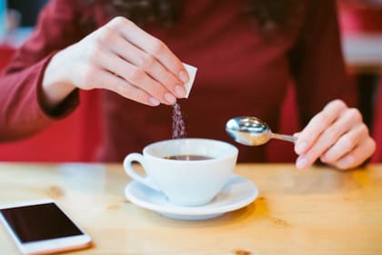 Persona pone edulcorante al té