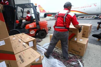 Personal aeroportuario en Carcas recibiendo la ayuda enviada desde China.
