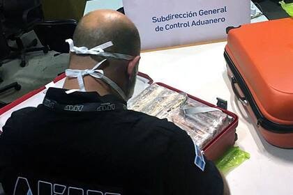 Un agente de Aduana de Ezeiza con las valijas que contenían la droga