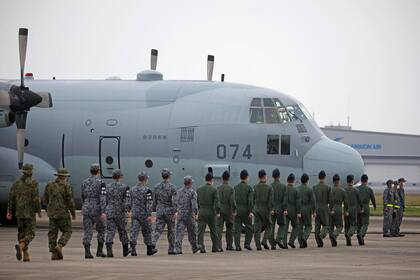 Personal de la Fuerza de Autodefensa sube a un avión de transporte C-130 de la Fuerza de Autodefensa Aérea antes de partir hacia Yibuti para preparar la evacuación de ciudadanos japoneses de Sudán, en la base aérea de Komaki, prefectura de Aichi, el 21 de abril de 2023.