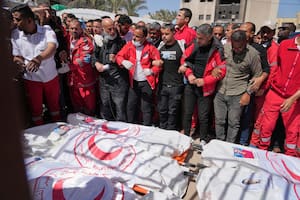 Personal de la Media Luna Roja se reúnen alrededor de los cadáveres de 8 integrantes del personal de emergencia de la Media Luna Roja, recuperados en Rafah una semana después de un ataque de soldados israelíes, al momento de ser transportados para su entierro de un hospital en Deir al-Balah, en la Franja de Gaza, el lunes 31 de marzo de 2025.