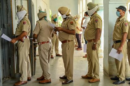 Personal de la policía hace fila mientras espera para analizarse en un hospital especial durante la cuarentena nacional impuesta por el gobierno como medida preventiva contra el coronavirus, en Amritsar el 22 de abril de 2020