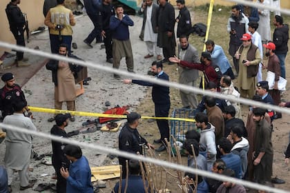 Personal de seguridad y residentes locales se reúnen en el lugar de una explosión dentro de una mezquita en Islamabad