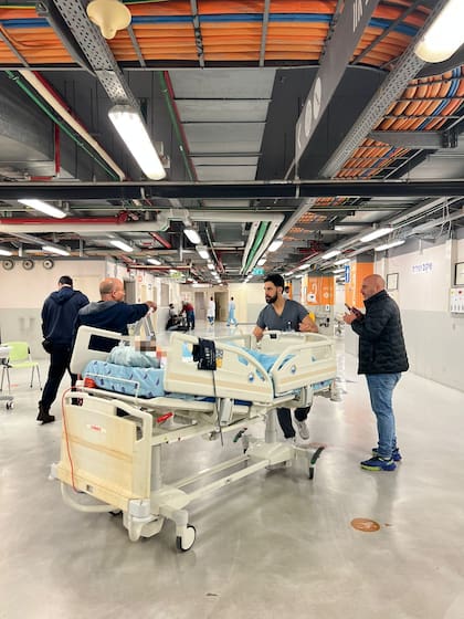 Personal del hospital Ichilov moviliza una cama pediátrica en uno de los niveles subterráneos que el centro médico habilitó para sostener la atención durante la emergencia