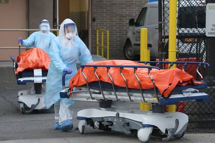 Personal del Wyckoff Heights Medical Center de Nueva York retira los cuerpos de dos personas fallecidas por el coronavirus